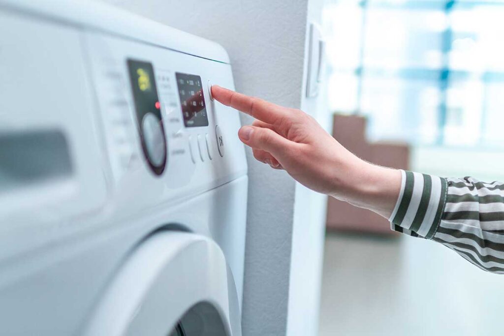 Bild zum Blogpost: 10 Fehler, die man beim Bedienen der Waschmaschine vermeiden sollte Hand bedient Programme einer Waschmaschine
